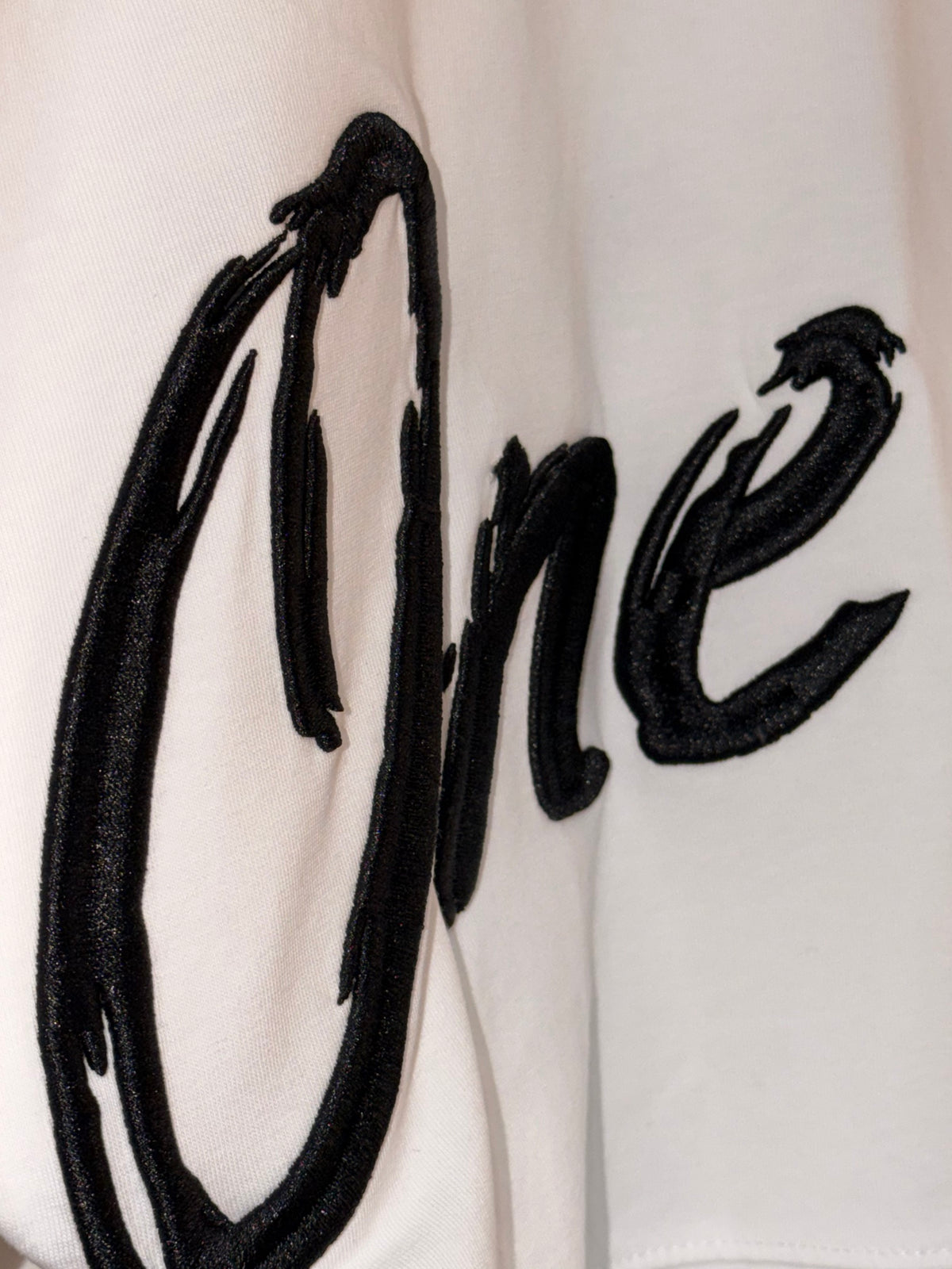 Zoom sur la broderie noir brillant One Island