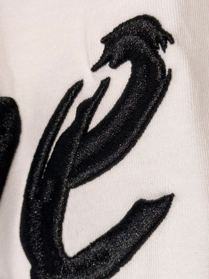 Détail de la broderie 3D noir brillant du T-shirt One Island